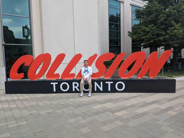 Sitting in front of the Collision logo at the 2022 edition of the conference.